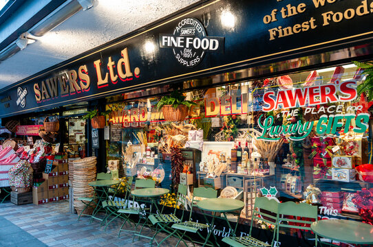Front exterior of Sawers Ltd, established 1897, gourmet delicatessen shop in College Street Belfast featuring green bistro outdoor seating.