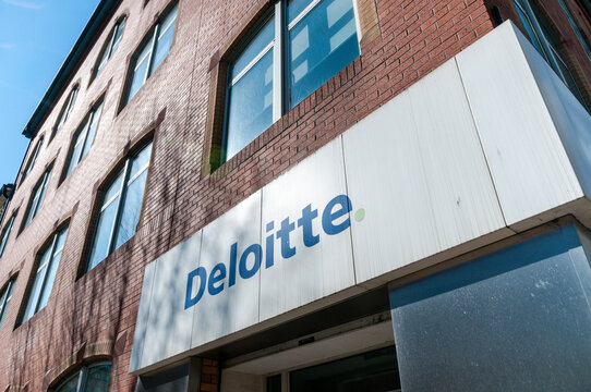 Exterior view of the Deloitte Touche Tohmatsu Limited professional services office entrance in Belfast, Northern Ireland, featuring modern signage on a brick facade