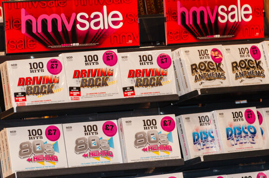Boxed sets of popular music CDs including rock, 80s and disco albums arranged on shelves during a promotional clearance sale at an HMV retail store