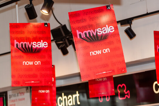 Signs and banners advertising a clearance sale displayed inside an HMV retail store, promoting discounted music, film, and entertainment merchandise to shoppers.