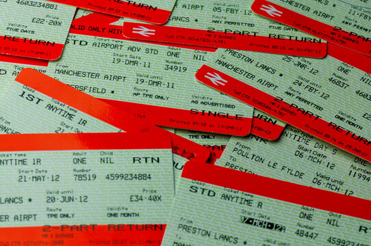 A high-angle, close-up studio shot featuring a disorganized pile of discarded paper rail tickets for travel between Manchester Airport and Preston, reflecting transit history and passenger travel.
