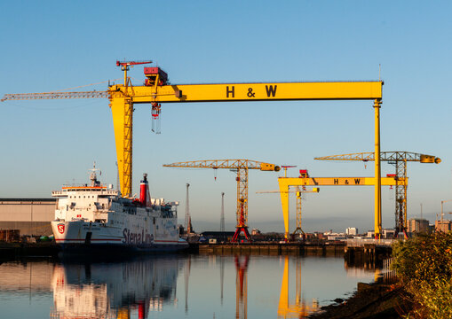 Samson and Goliath, the iconic Harland and Wolff gantry cranes, tower over the Belfast skyline, serving as a historic monument to Northern Ireland's shipbuilding legacy and industrial past.