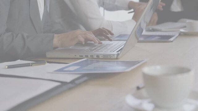Team reviewing business charts while man tapping tablet starting woman typing laptop logging notes