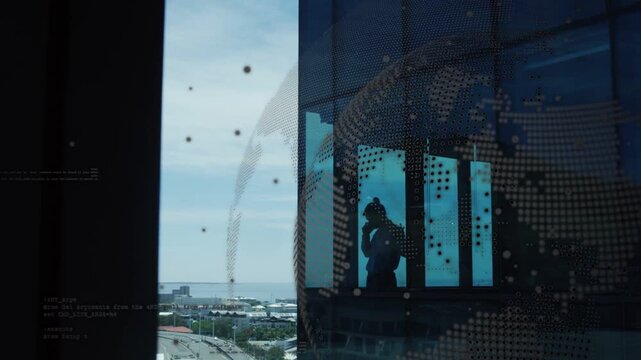 Exec receiving business call while holding phone, globe across glass over silhouette revealing city