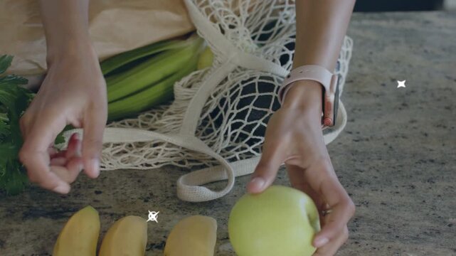Woman placing mesh tote on stone top, arranging bananas for food prep, swirls popping over fruit