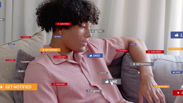 Adult male on couch typing and scrolling laptop, causing online badges appearing, signaling growth