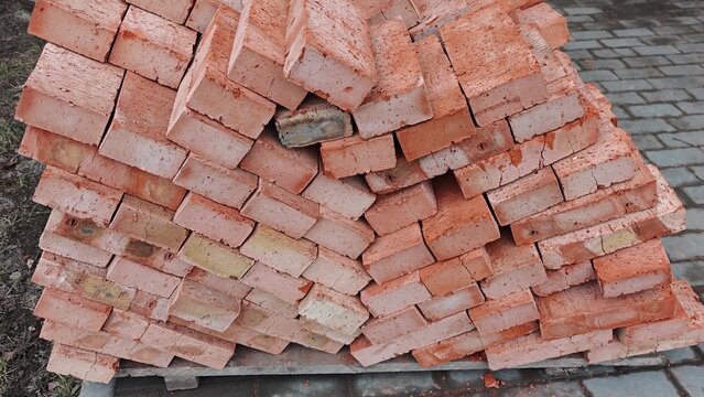 Stacked orange bricks arranged in a pyramid shape on a stone pavement, showcasing the gradual shift in perspective and alignment across the frames