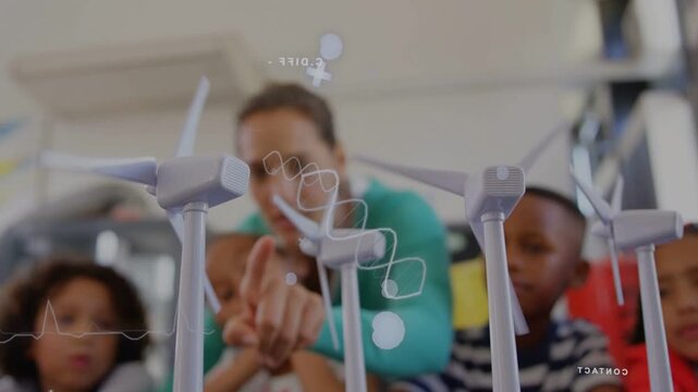 Teacher pointing at table turbines, students leaning while white overlays tracking finger for STEM