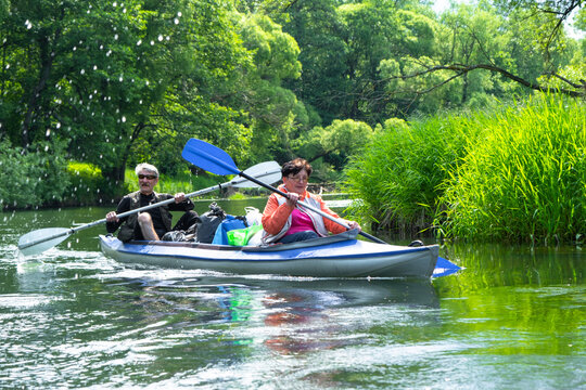Older married couple kayaking on a Varzuga kayak, enjoying water adventure and outdoor activity, mature tourism.