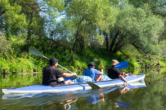 Family in the Vuoksa kayak paddling a summer river route, teamwork, outdoor recreation with child and fun nature tourism.