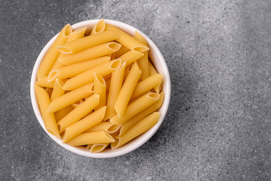 Italian uncooked dry penne regate pasta ready for cooking. Dry penne pasta
