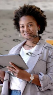 Vertical video: Woman tapping tablet, overlay symbols appearing, looking up and smiling to demo app