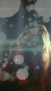 Vertical video: Singer holding mic leaning in singing music as bokeh drifting across singer and kit