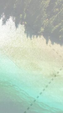 Vertical video: Dotted path appearing, aerial view shifting shore-to-forest, curving to guide route