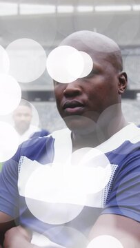 Vertical video: Man posing in stadium, camera panning nudging head, bokeh over jersey, sports promo
