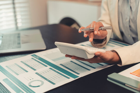 Business professionals are discussing charts and graphs that display successful results in order to analyze financial reports, plan strategies, and improve efficiency.