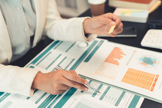 Business professionals are discussing charts and graphs that display successful results in order to analyze financial reports, plan strategies, and improve efficiency.