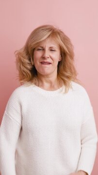 Happy mature woman dancing ecstatically, full of energy and positive emotions. Caucasian lady celebrating success and enjoying life