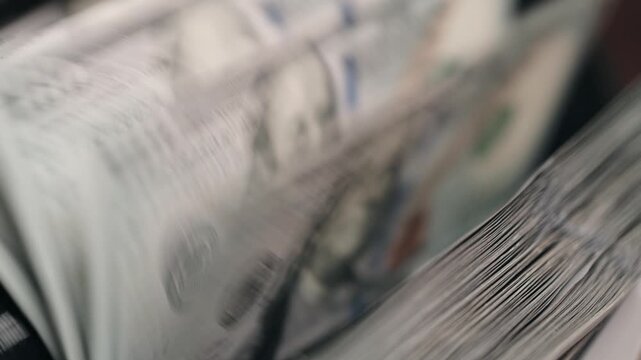 Automatic counting of US dollar cash in modern money counter device. Concept payroll processing and financial management.
