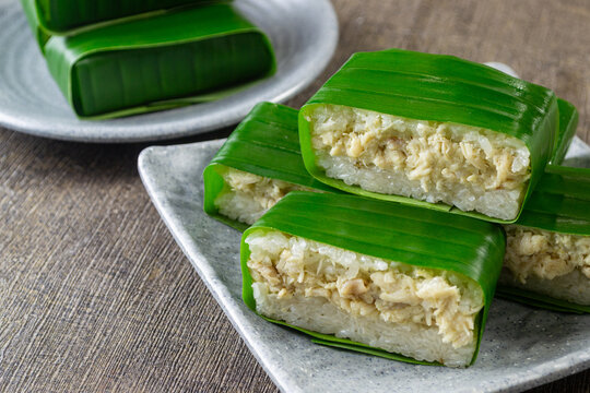 Lemper Ayam, Indonesian Traditional snack of savory steamed glutinous sticky rice filled with seasoned shredded chicken,  wrapped in banana leaves