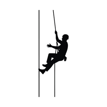 Silhouette of a rock climber rappelling down a steep vertical cliff face