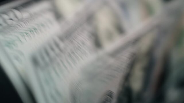 Close-up sequence of cash being counted, showcasing detailed textures of banknotes and coins in a dimly lit environment with a focus on monetary exchange