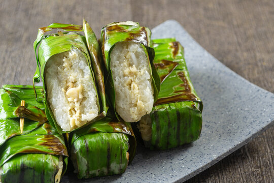 Lemper Ayam bakar, Indonesian Traditional snack of savory steamed glutinous sticky rice filled with seasoned shredded chicken, wrapped and grilled in banana leaves