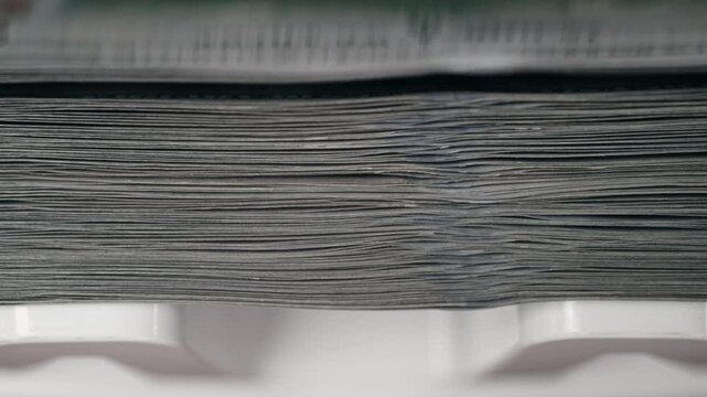 Close-up view of stacked currency notes showing detailed texture and alignment, highlighting the progression of cash in a white container for financial context