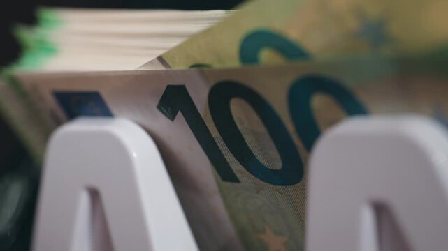 Currency counter machine processing euro banknotes with high accuracy in close-up. Concept financial monitoring and cash control.

