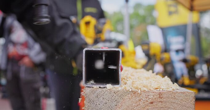 Close-up view of a professional technician using a heavy-duty fastening tool screw driving tool to drive a steel nail into a metal pillar. Industrial construction,steelwork,diy home