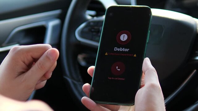 Close-up of a person dialing a debtor via a specialized mobile interface inside a vehicle. Ideal for videos about financial struggle, personal debt, and credit recovery solutions. Realistic digital
