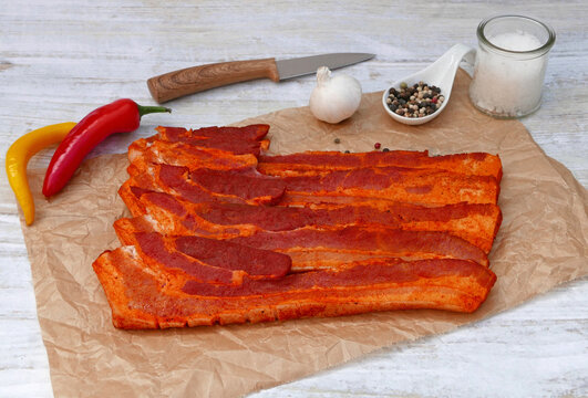Frisch marinierte Schweinebauchscheiben mit Gew&uuml;rzen und Chili auf Pergamentpapier".