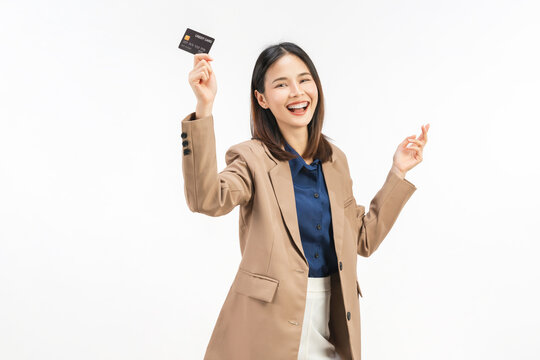 Happy young Asian businesswoman holding credit cards and a confident smile isolated on white studio background.