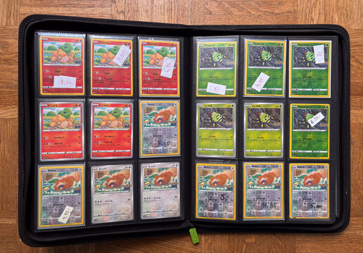 Hamburg, Germany - 04042026: open trading card binder filled with multiple unpeeled Ditto Pok&eacute;mon cards from the Pok&eacute;mon GO set, displayed on a wooden floor with price notes.