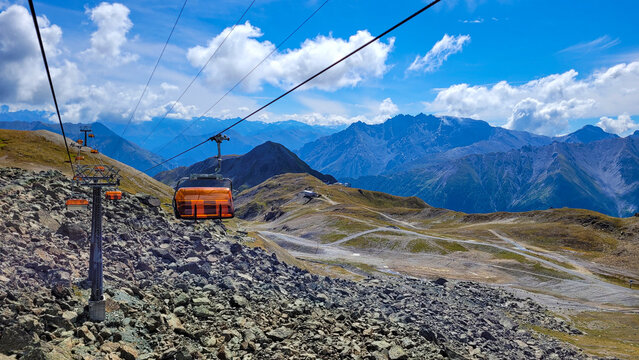 Vire of the picturesque Tirol Alps with cable car with orange cabins on the border with Switzerland.