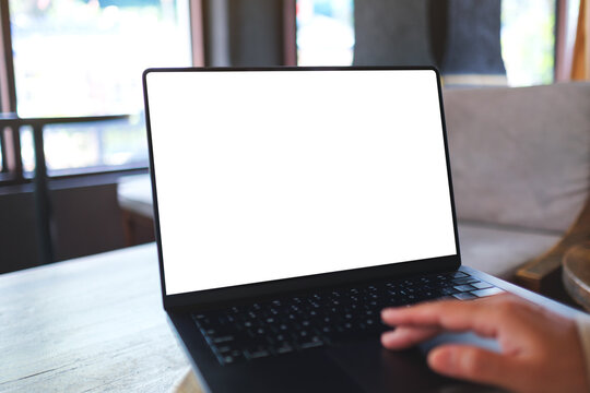 Mockup image of a woman working and touching on laptop computer touchpad with blank white desktop screen in cafe