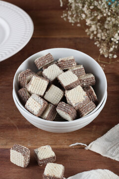 bowl com biscoito tipo waffer em cubos sobre mesa de madeira