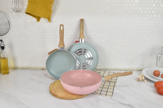 Minimal kitchen cookware and utensils arranged with fresh vegetables