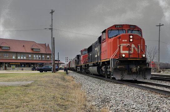 Two locomotive units power an eastbound Canadian National merchandise freight train past the historic Durand Union Station while taraveling along CN's Flint Subdivision.  