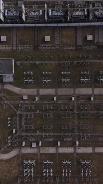 Vertical screen Aerial View Power Grid Warsaw, Organized Rows Of Switchgear And Conduits, Service Paths, Industrial Rooftops, Muted Palette, Technician Planning Inspection