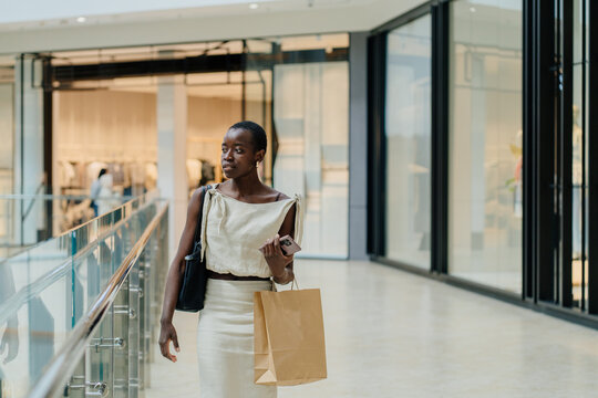 Sophisticated Black Woman Walking in Contemporary Shopping Mall