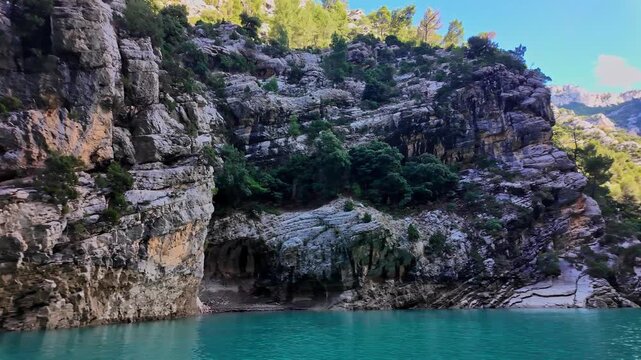 Boat trip on turquoise water of mountain canyon, Verdon Gorge in french Alps, Provence France. Near Aiguines. Canyon is about 25 kilometres long and up to 700 metres deep.