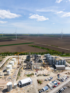 Construction of a modern agricultural grain terminal with wind turbines on the horizon