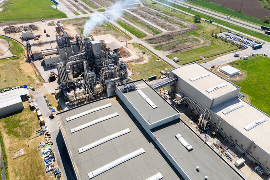 Aerial shot of a manufacturing facility with smoking chimney during production