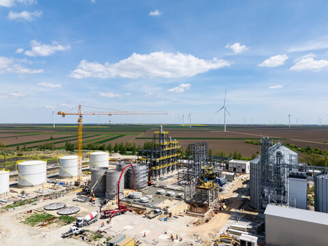 Construction of a modern agricultural grain terminal with wind turbines on the horizon