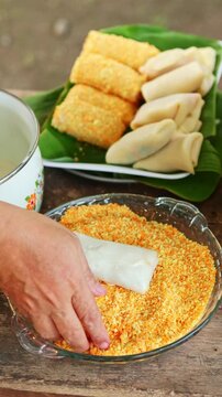 Preparing traditional Indonesian spring rolls called risoles with breadcrumbs