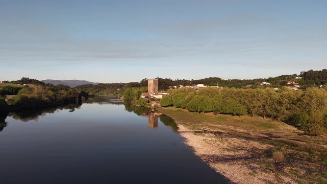 Lapela tower a medieval castle reflecting in the calm waters of minho river