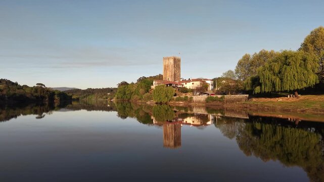 Lapela tower a medieval castle reflecting in the calm waters of minho river