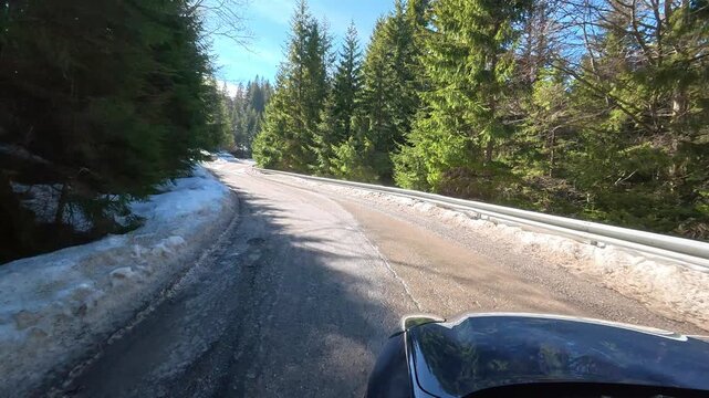 Car ride on a spring day in the Carpathian Mountains, a winding mountain road.