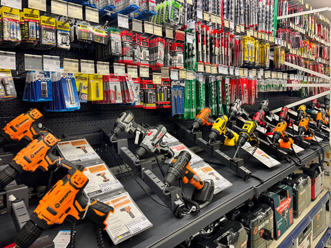 Barnaul, Russia, 06.06.2025: Hardware store display of cordless drills and power tools on retail shelves with drill bits and accessories. A well-stocked tool department.